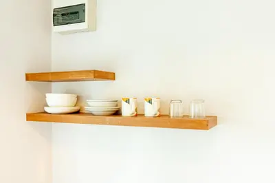 a shelf with bowls and glasses on a wall at Ascella Sukhumvit 38 - Thonglor in Bangkok