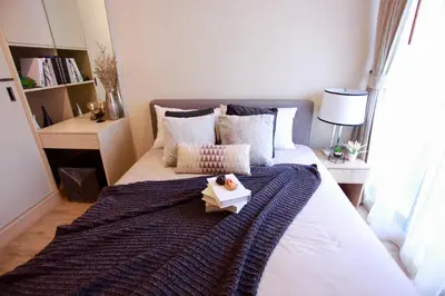 a bedroom with a bed with a book on it at Comfy Condo On Nut in Bangkok