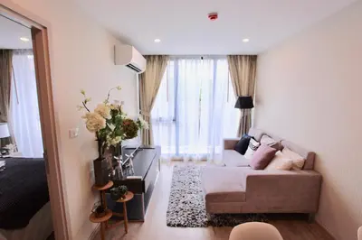 a living room with a couch and a table at Comfy Condo On Nut in Bangkok