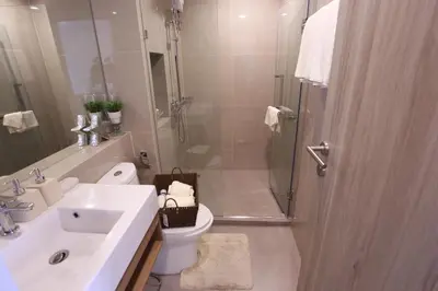 a bathroom with a shower and a toilet and a sink at Comfy Condo On Nut in Bangkok
