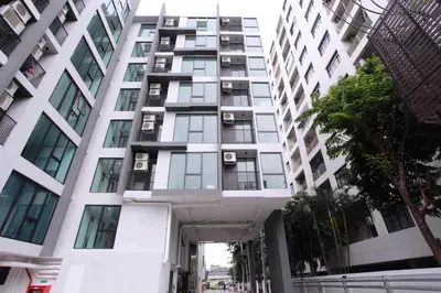 a tall white building with windows at Comfy Condo On Nut in Bangkok