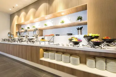 a restaurant with plates on a counter at Madison Bangkok Hotel in Bangkok