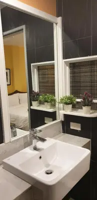 a bathroom with a white sink and a mirror at Vinary Hotel Sukhumvit in Bangkok