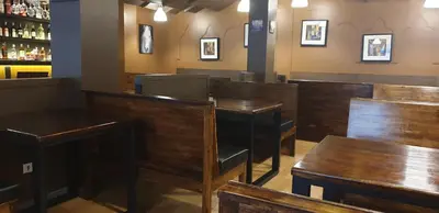 a restaurant with wooden tables and chairs and a bar at Vinary Hotel Sukhumvit in Bangkok