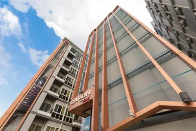 two tall buildings in front of a blue sky at Baron Residence Bangkok in Bangkok