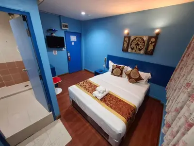 a blue room with a bed and a shower at Wow Guesthouse in Bangkok