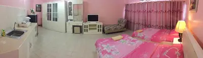 a pink room with two beds and a mirror at SK Muang Thong Thani in Bangkok