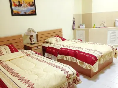 a bedroom with two beds and a table with a lamp at SK Muang Thong Thani in Bangkok