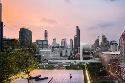 a city skyline with a person standing on a rooftop at Sindhorn Midtown Hotel Bangkok, Vignette Collection by IHG in Bangkok