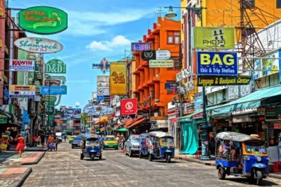 a busy city street filled with lots of signs and vehicles at Wild Orchid Villa Bangkok in Bangkok