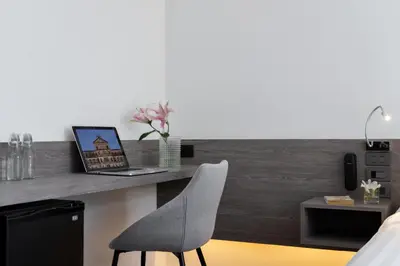 a bedroom with a desk with a laptop and a chair at Amarin Hotel Rama 8 in Bangkok