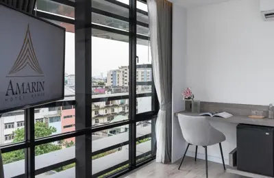 an office with a desk and a large window at Amarin Hotel Rama 8 in Bangkok
