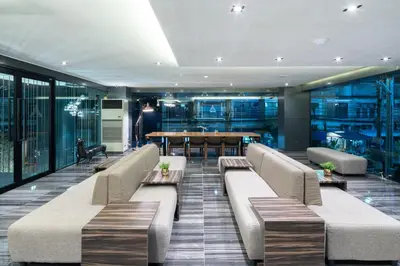 a lobby with couches and a dining room with a table at Amarin Hotel Rama 8 in Bangkok