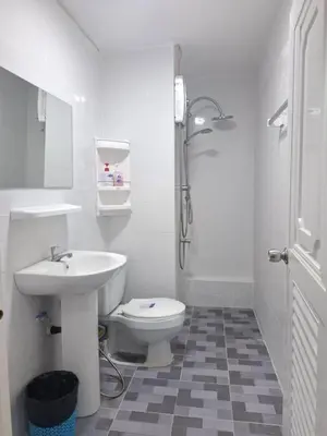 a white bathroom with a toilet and a sink at K.NAT Room service in Nonthaburi