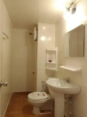 a white bathroom with a toilet and a sink at K.NAT Room service in Nonthaburi