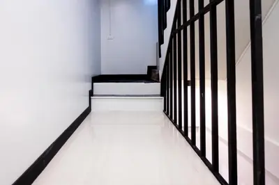 a white hallway with a staircase with black railings at T5 2 Bedrooms/6guests/full kitchen/1 min to BTS in Bangkok