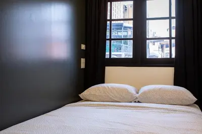 a bed with two pillows in a bedroom with a window at T5 2 Bedrooms/6guests/full kitchen/1 min to BTS in Bangkok