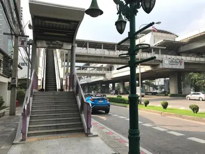 a blue car is driving down a street with a staircase at T5 2 Bedrooms/6guests/full kitchen/1 min to BTS in Bangkok