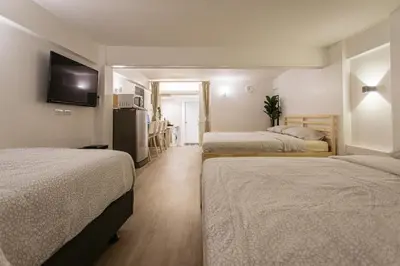a hotel room with two beds and a television at B2 Large + Comfort full kitchen near MRT Bangson in Bangkok