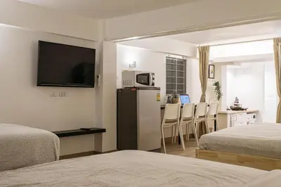 a room with two beds and a kitchen with a refrigerator at B2 Large + Comfort full kitchen near MRT Bangson in Bangkok