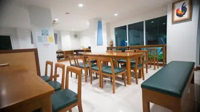 a dining room with a table and chairs at The Willing Hotel and Residence in Lak Si