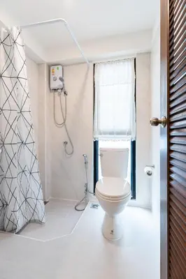 a bathroom with a toilet and a shower at Baan Boon in Bangkok