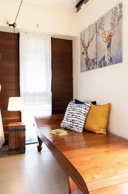 a living room with a wooden bench and a window at Baan Boon in Bangkok