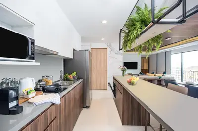 an open kitchen with a large island with a counter top at Amanta Hotel & Residence Sathorn in Bangkok