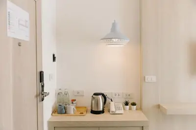 a kitchen with a table with a kettle and a light at Nappiness Hotel in Bangkok
