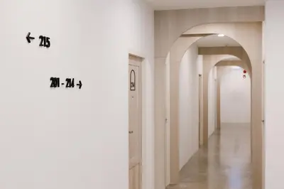 a hallway with white walls and an archway at Nappiness Hotel in Bangkok