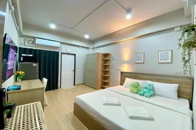 a bedroom with a bed with a teddy bear on it at 44 Room Rama 3 in Bangkok