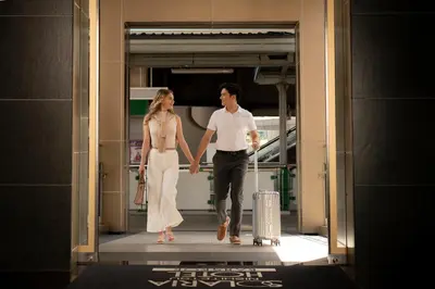 a man and a woman walking through a doorway with their luggage at Solaria Nishitetsu Hotel Bangkok in Bangkok