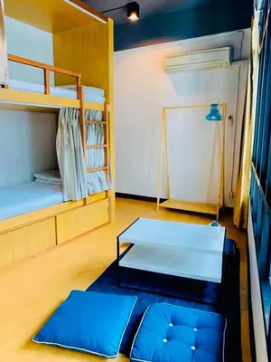 a room with two bunk beds and a table at Daraya Hostel in Bangkok