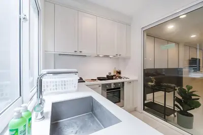 a kitchen with white cabinets and a sink at MIQ Asoke808 Villa - Asoke BTS - garden pool - 16 Pax in Bangkok