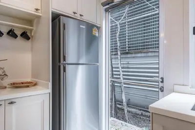 a stainless steel refrigerator in a kitchen with a window at MIQ Asoke808 Villa - Asoke BTS - garden pool - 16 Pax in Bangkok