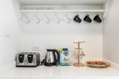 a kitchen counter with a coffee maker and coffee cups at MIQ Asoke808 Villa - Asoke BTS - garden pool - 16 Pax in Bangkok