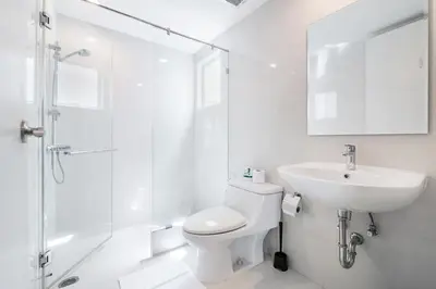 a white bathroom with a toilet and a sink at MIQ Asoke808 Villa - Asoke BTS - garden pool - 16 Pax in Bangkok