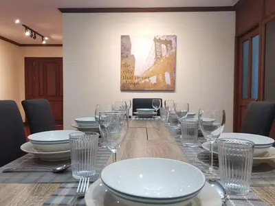 a table with glasses and plates on top of it at NT Place Sukhumvit Suites in Bangkok