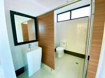 a bathroom with a toilet and a sink and a window at NT Place Sukhumvit Suites in Bangkok
