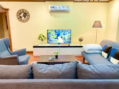 a living room with a couch and a tv at NT Place Sukhumvit Suites in Bangkok