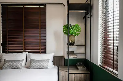a bedroom with a white bed and a plant at KLYDE Boutique - Chatuchak in Bangkok