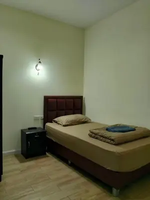 a bedroom with a bed and a night stand at Mangkon Hostel in Bangkok