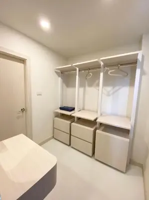 a room with white cabinets and drawers and a bed at Mangkon Hostel in Bangkok