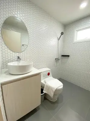 a bathroom with a sink and a toilet and a mirror at Mangkon Hostel in Bangkok