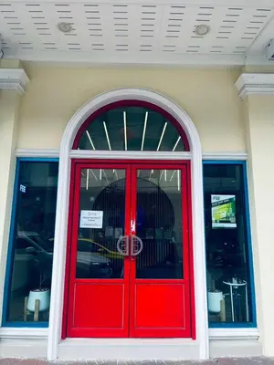 a red door on a building with a window at Mangkon Hostel in Bangkok