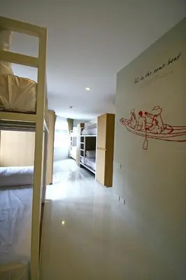 a room with a bed and a wall with a picture on it at CHERN Bangkok in Bangkok