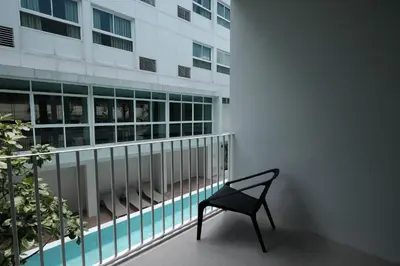 a chair sitting on a balcony in front of a building at CHERN Bangkok in Bangkok
