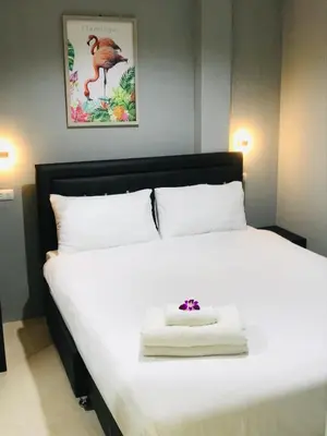 a bedroom with a white bed with a flower on it at HARRYS RESIENDENCE in Bangkok