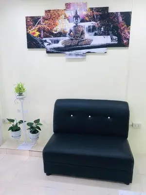 a black couch in a room with pictures on the wall at HARRYS RESIENDENCE in Bangkok
