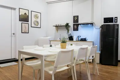 a white dining room table with white chairs and a refrigerator at U4 Large 2 bed rooms full kitchen 200m to BTS in Bangkok